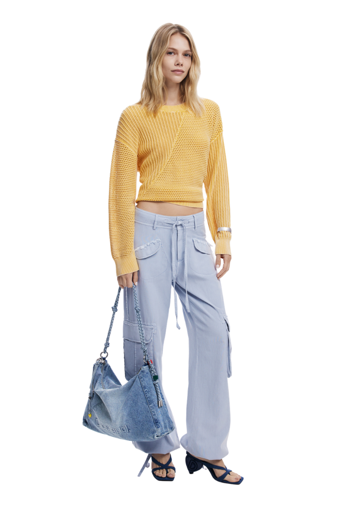 A woman modeling a yellow ribbed knit cropped sweater, light blue wide-leg cargo pants, and a blue denim shoulder bag against a plain white background.