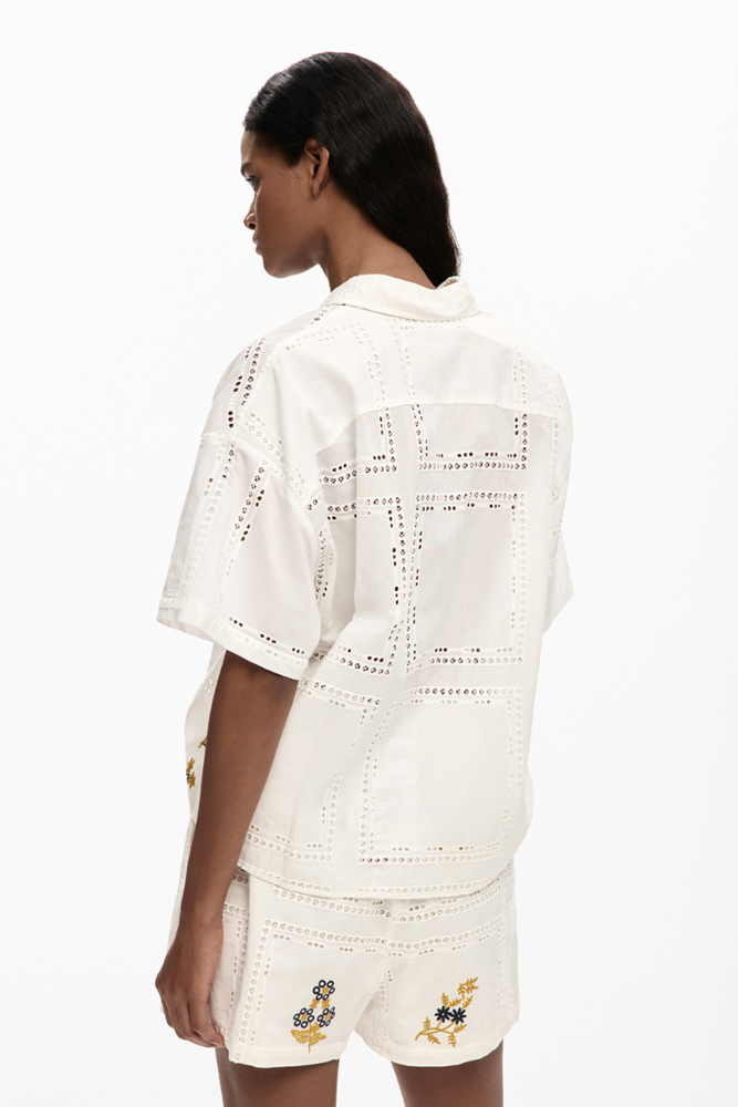 Woman wearing a white embroidered outfit on a white background