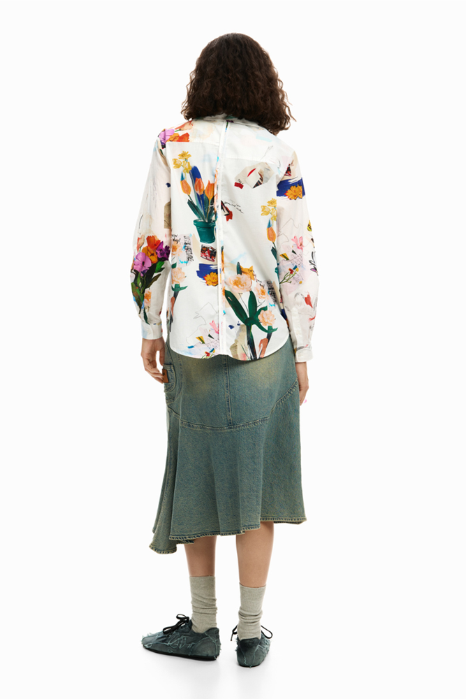 Person wearing a colorful floral-patterned shirt and green skirt on a white background