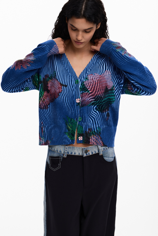 Woman wearing a blue patterned cardigan over a denim jacket
