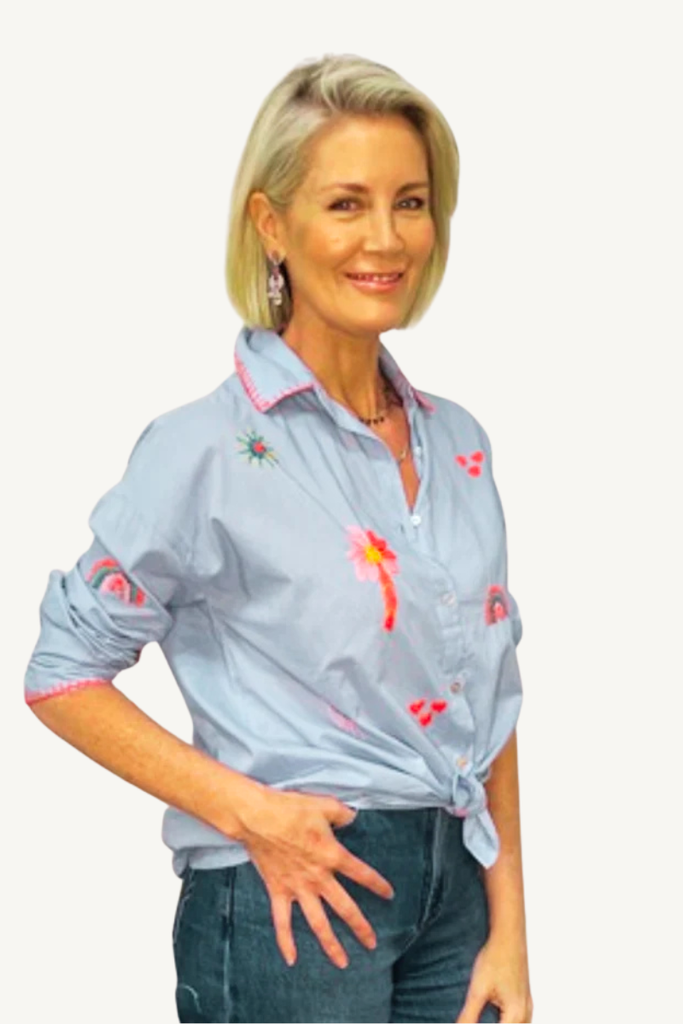 Woman wearing a light blue shirt with pink accents on a white background