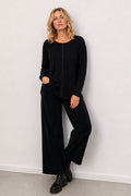 Woman wearing a black outfit against a white background