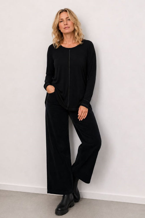 Woman wearing a black outfit against a white background