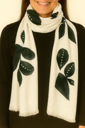 White scarf with black leaf patterns worn by a person