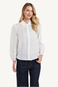 Woman wearing a white blouse and dark pants on a white background