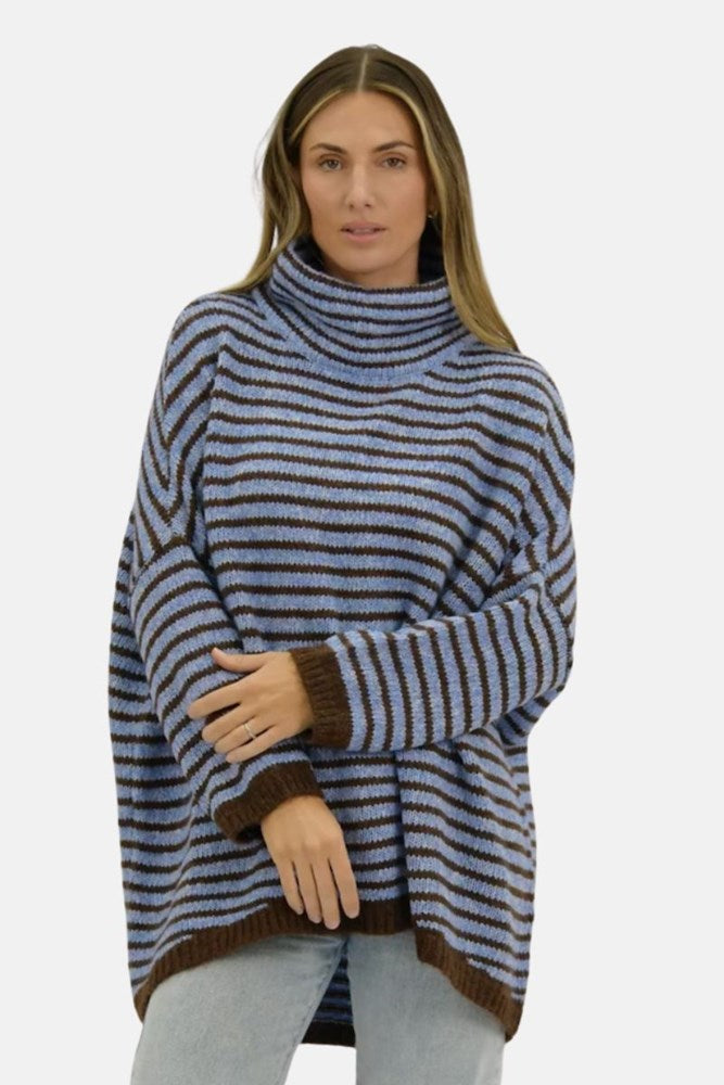 Woman wearing a blue and brown striped sweater on a white background