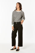 Woman wearing a checkered shirt and black pants on a white background