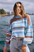 Woman wearing a striped sweater by the water