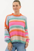 Woman wearing a colorful striped sweater on a white background