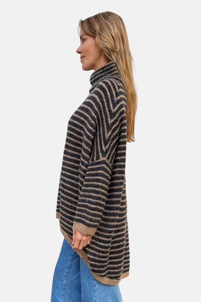 Woman wearing a striped sweater and blue jeans on a white background
