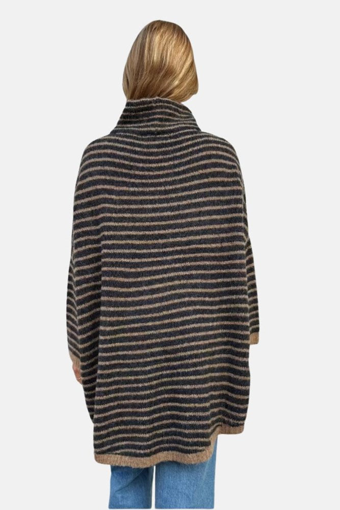 Person wearing a striped poncho on a white background